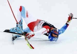 Ski racer falls on snow during race.