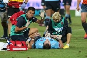 Rugby player receiving medical aid on a.