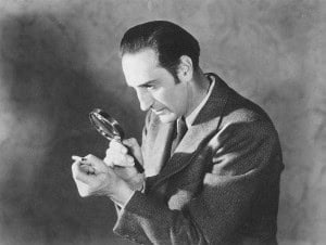 Man examining a small object with a magn.