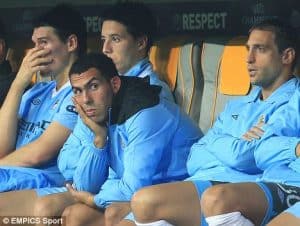 Sports team sitting on bench at match.