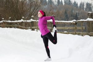 Woman running in snowy landscape.