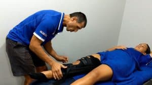Physiotherapist examining patient's leg.