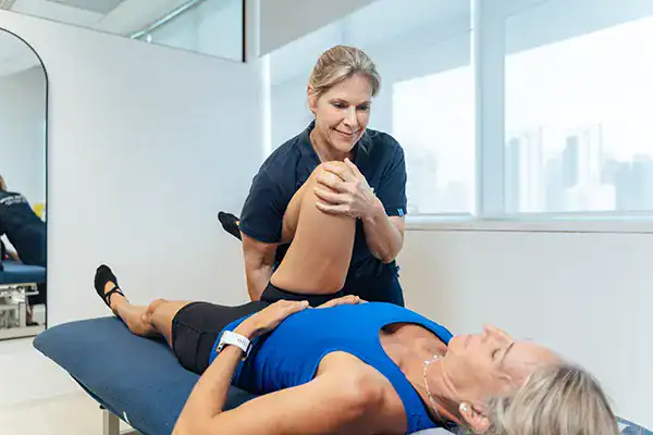 Physiotherapist treating a woman in a cl.