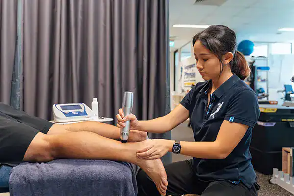 Physiotherapist treating patient's leg.