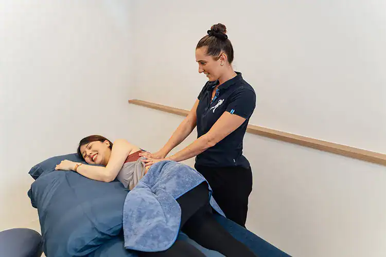Physiotherapist treating postnatal woman.