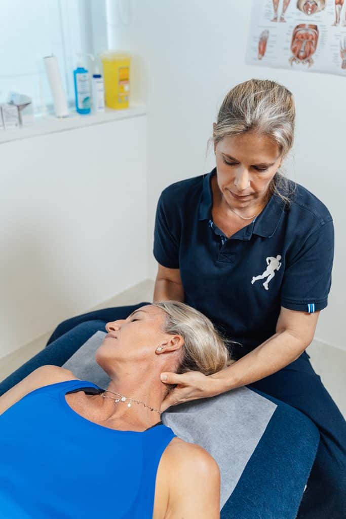 Physiotherapist treats neck pain at spa.