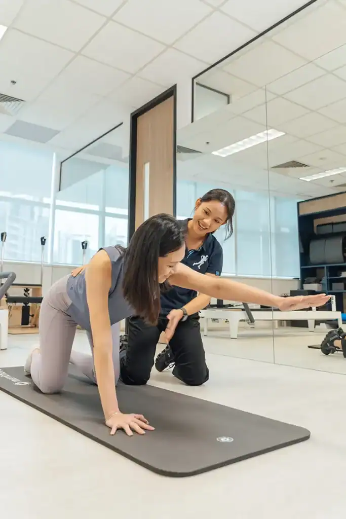Physiotherapist guiding pregnant woman.